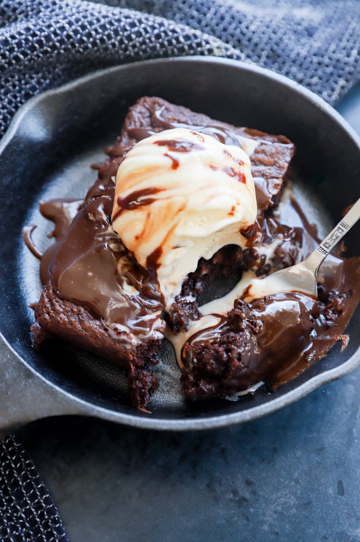 fork taking a bite out of a sizzling brownie ice cream sundae