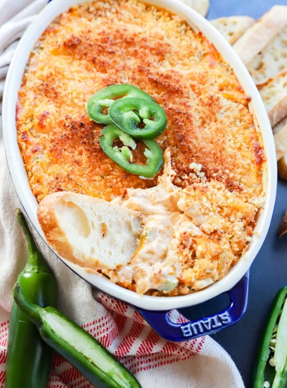 bread slice in pan of cheesy appetizer after being baked