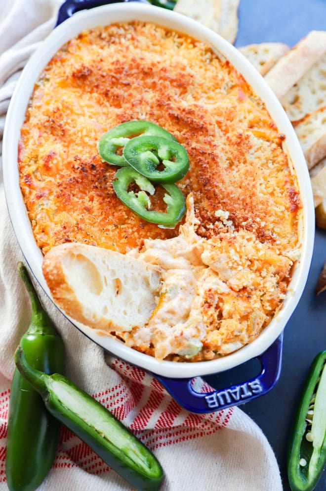 bread slice in pan of cheesy appetizer after being baked
