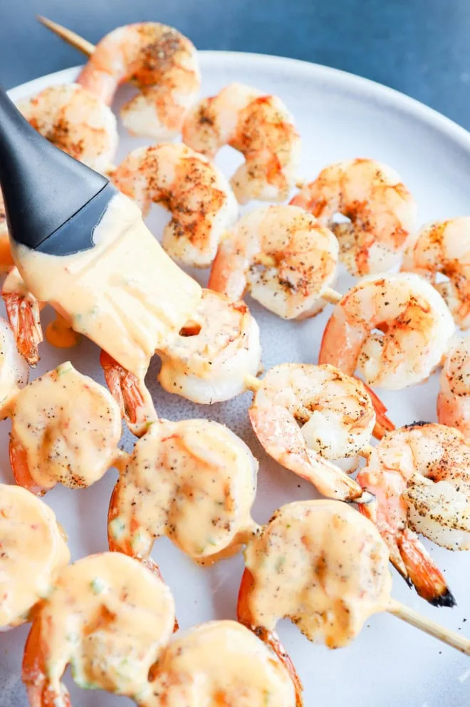 Brushing bang bang sauce on shrimp