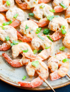 Easy grilled seafood skewers with sauce and green onion on top
