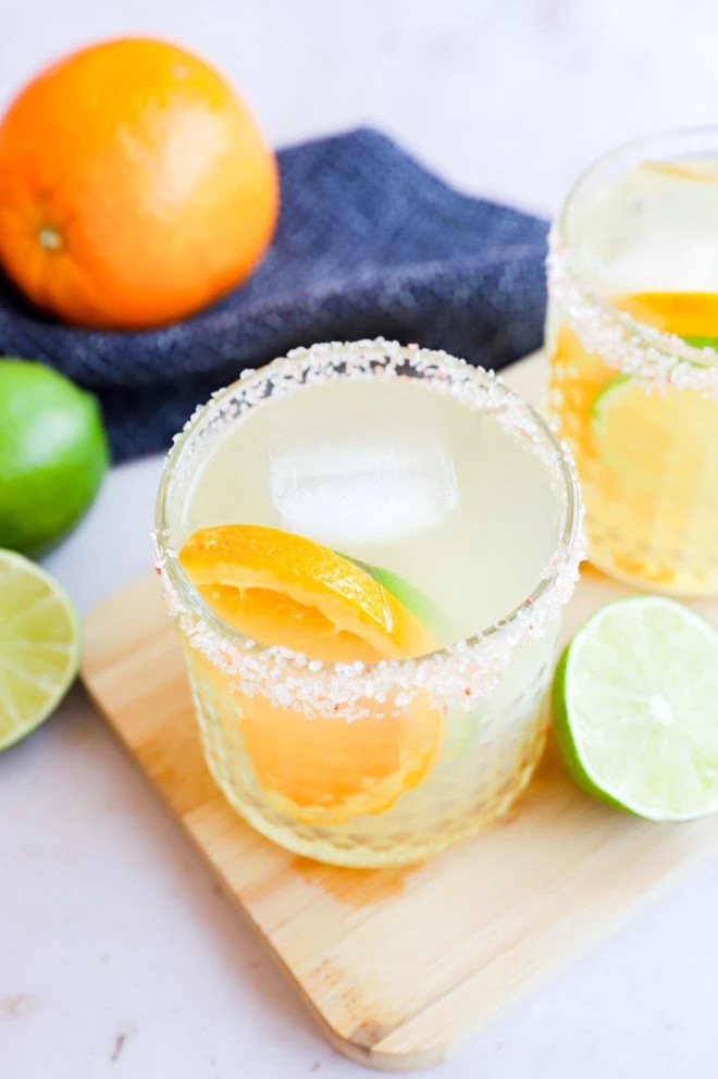 Citrus slices in a cocktail glass with drink with fresh lime and orange