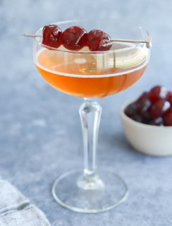 Low ABV cocktail in a coupe glass with cherry garnish