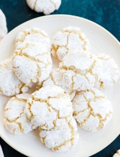 pretty cracked amaretti cookies on plate with linen and green countertop
