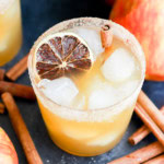 glass of apple fall drink in glass full of ice with cinnamon stick garnish