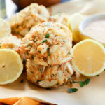 stack of easy seafood appetizer with fresh lemons in bowl and white wine and sauce