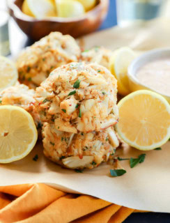 stack of easy seafood appetizer with fresh lemons in bowl and white wine and sauce