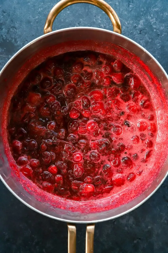 making cranberry simple syrup in a saucepan