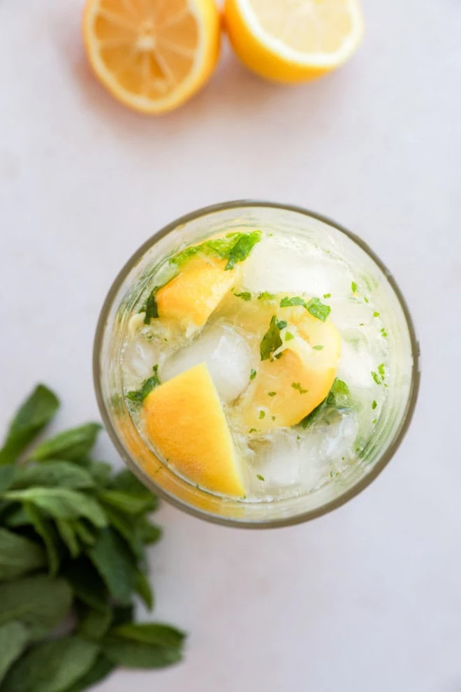 muddled bourbon smash in shaker with lemons and mint