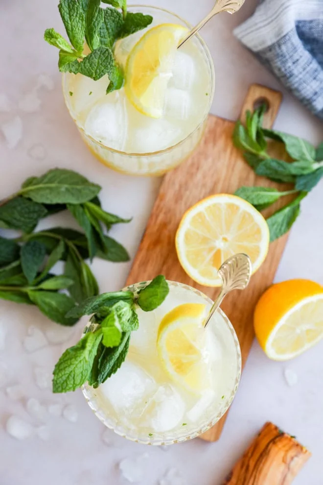 image of lemon cocktail in glasses with fresh mint and cutting board