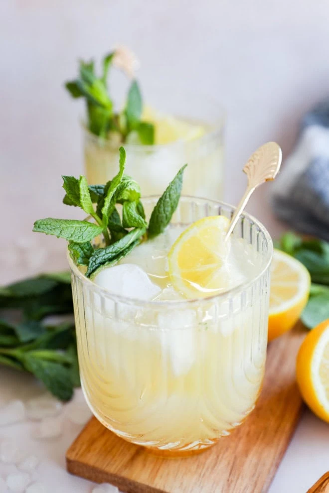 cocktail glasses with whiskey lemon and mint cocktail