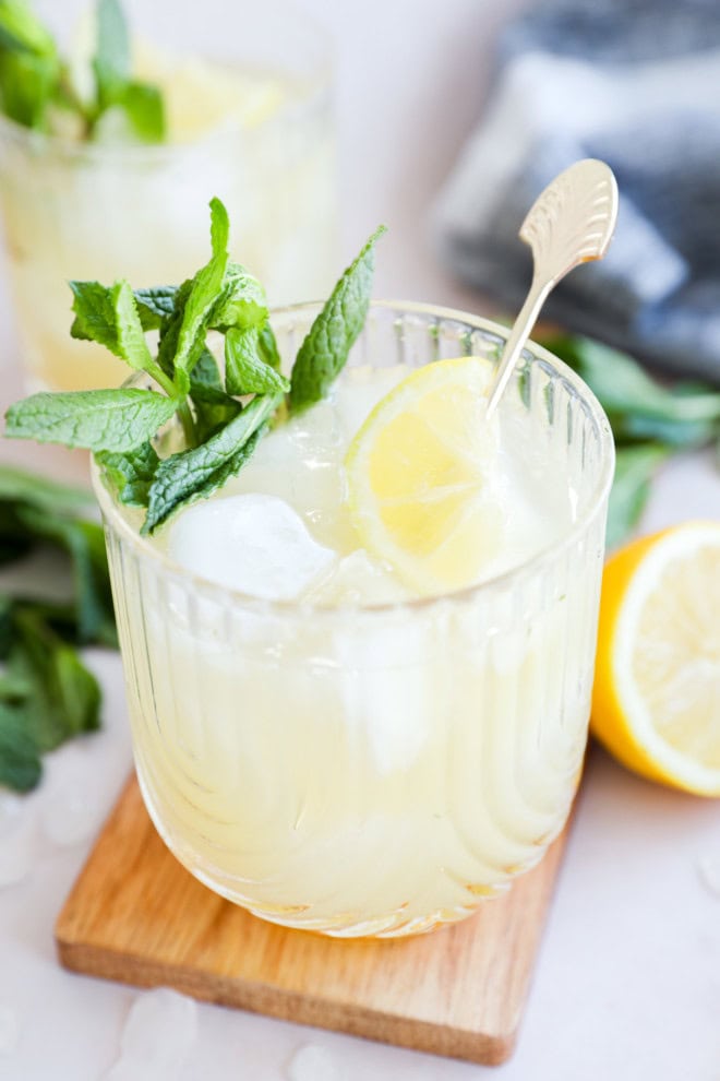 bourbon smash in cocktail glass with fresh lemon and mint
