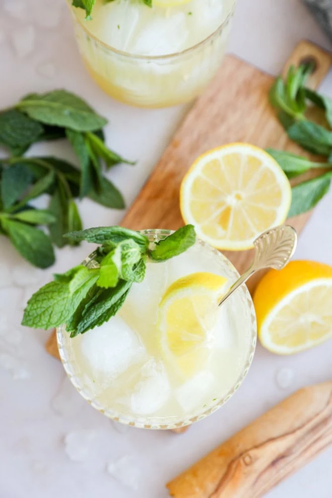 cocktail glasses with mint and lemon with muddler and cutting board