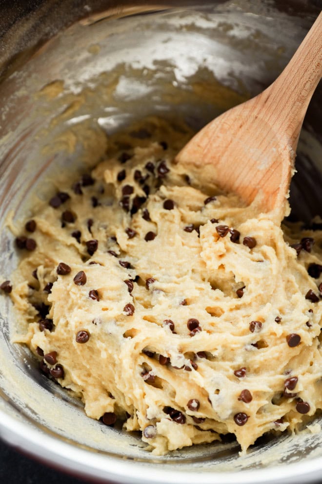 mini chocolate chip muffins batter in a bowl with wooden spoon