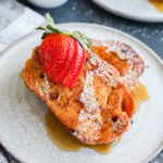sourdough french toast slices on a plate with fresh fruit