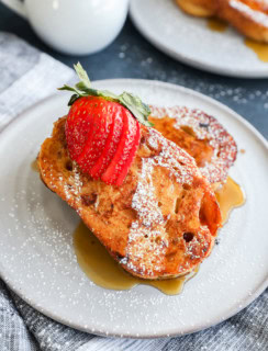 sourdough french toast slices on a plate with fresh fruit