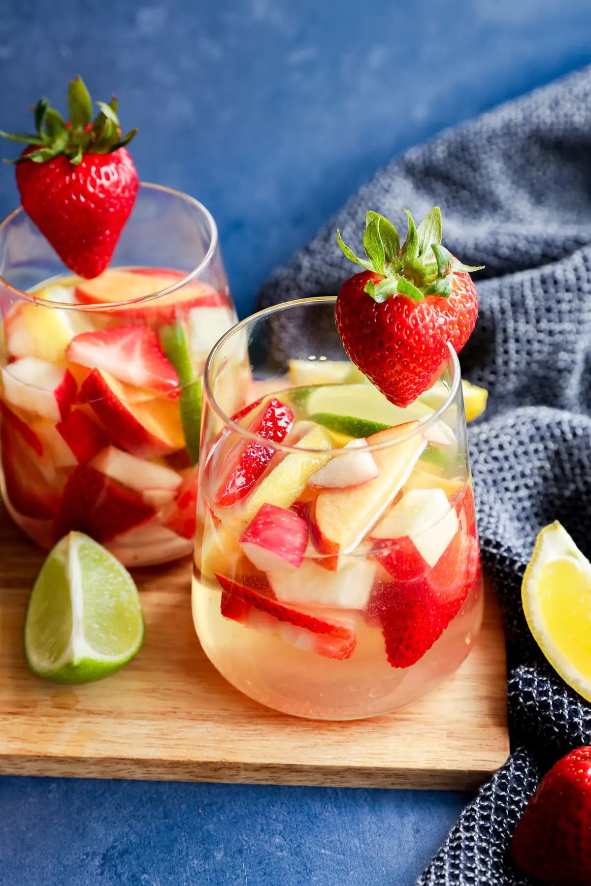 White sangria with white wine, fresh fruit and citrus on wood