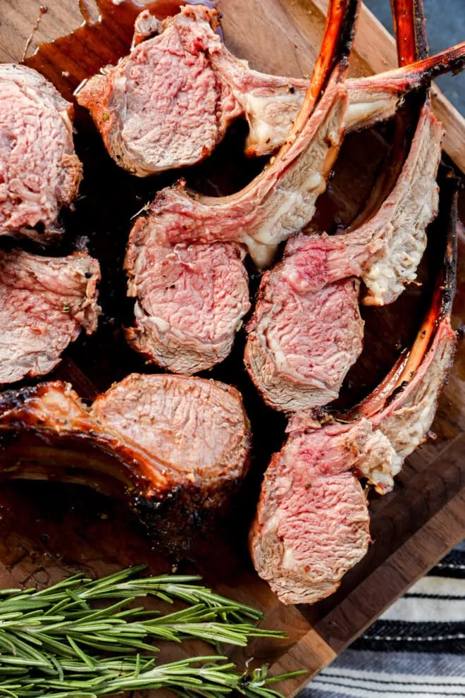 sliced meat on cutting board with fresh rosemary