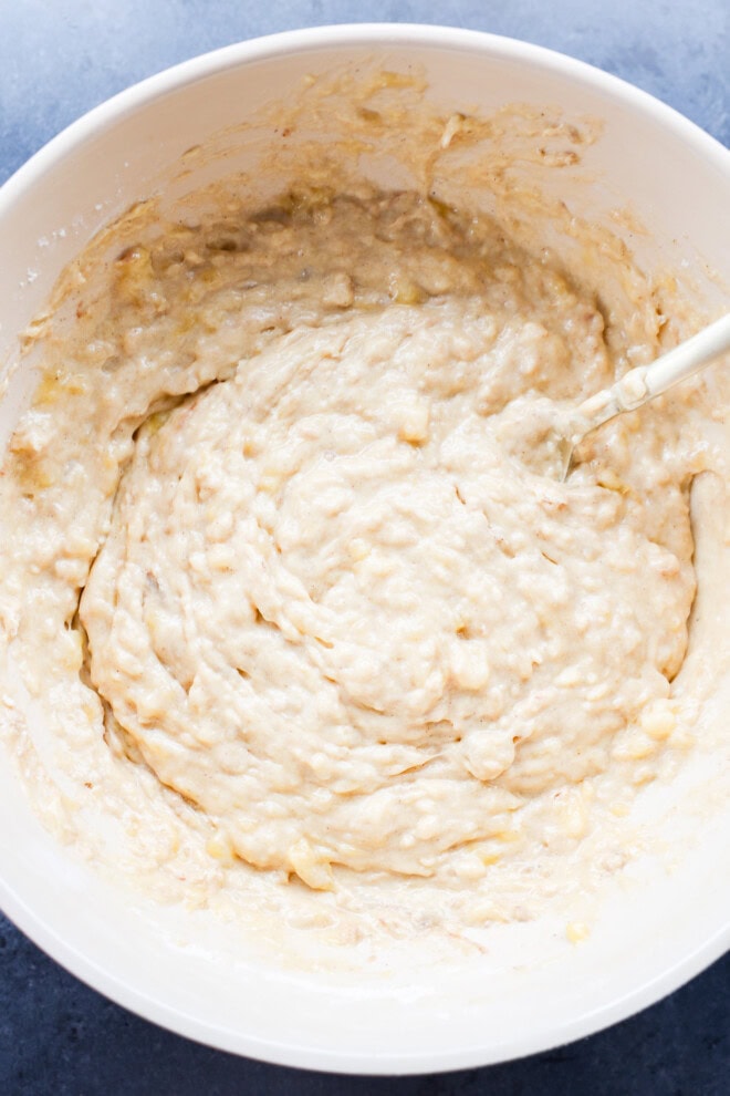 mixing the muffin batter in a bowl with a spatula