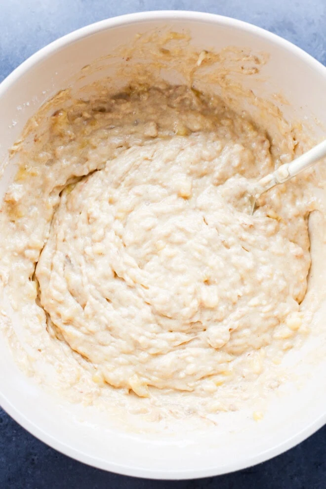 mixing the muffin batter in a bowl with a spatula