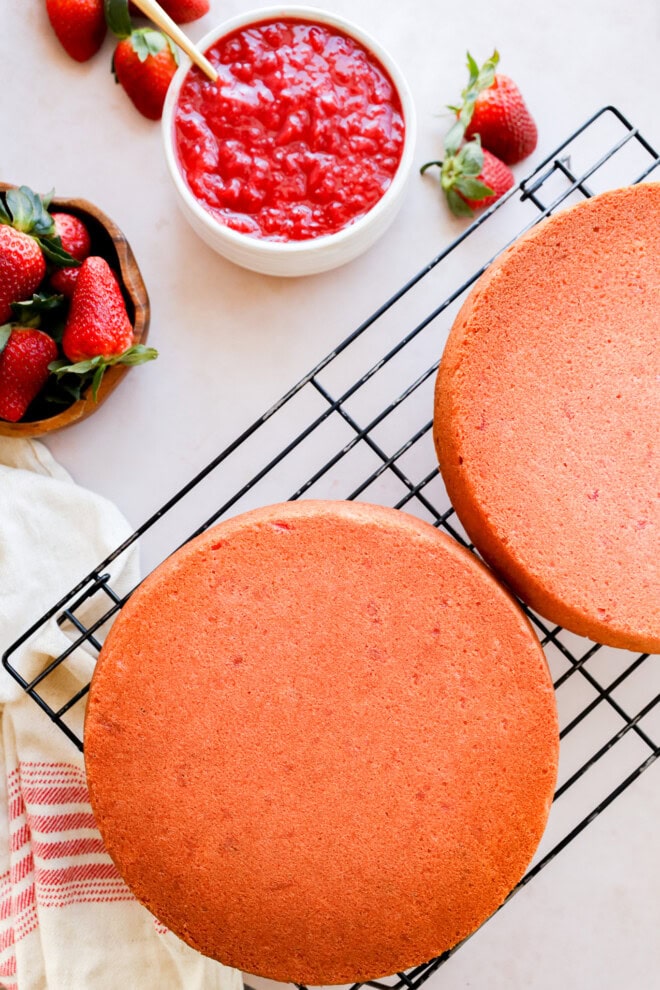 layers of strawberry cake cooling on wire rack