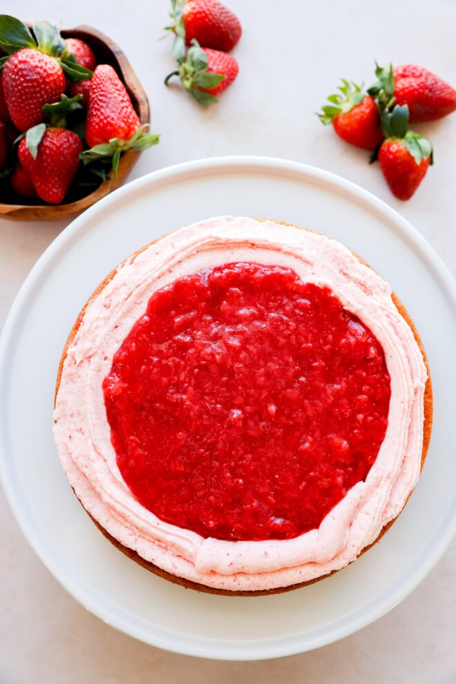 cake with strawberry filling and buttercream during layering process