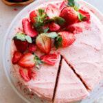 cutting a slice of fresh berry pink dessert with fresh fruit on top