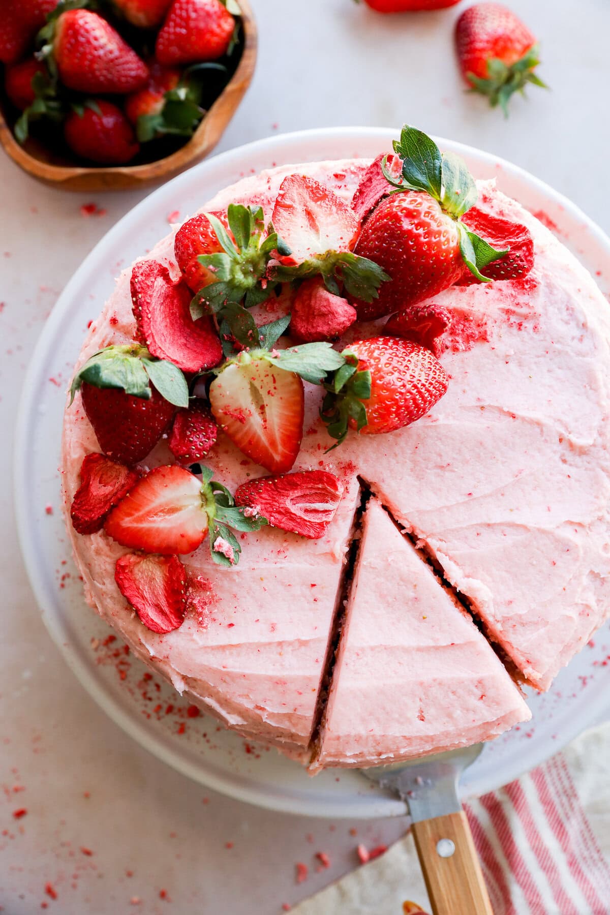 cutting a slice of fresh berry pink dessert with fresh fruit on top