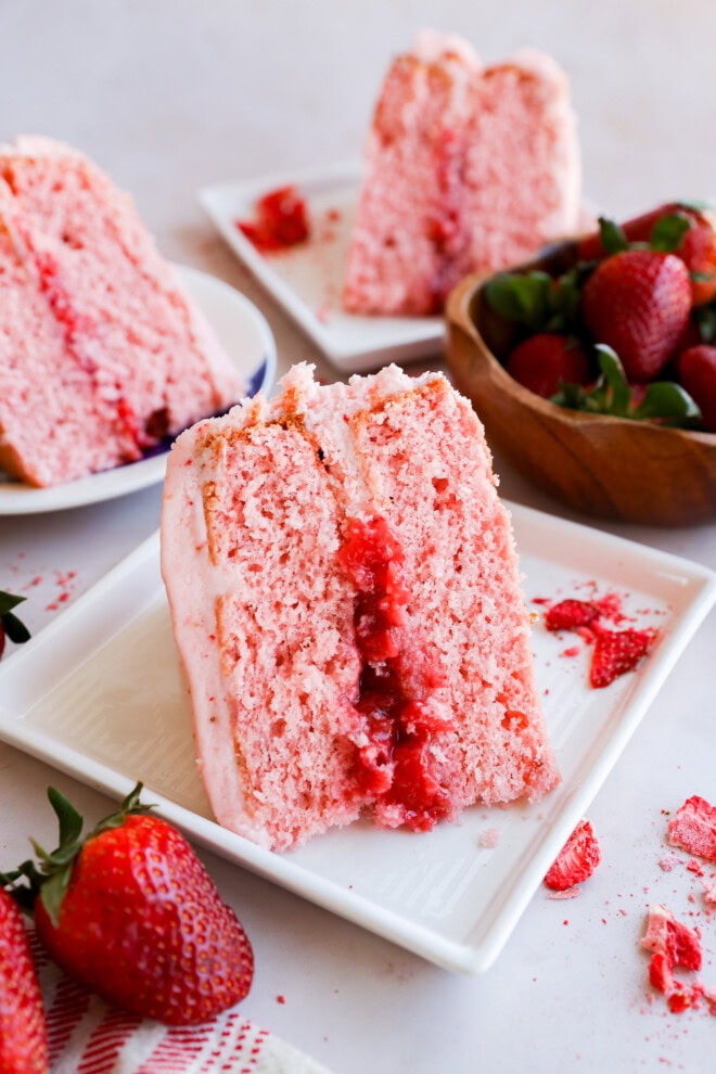 plates of slices of pink dessert with fresh fruit in the center and pink frosting