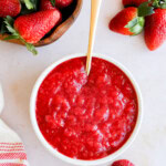 strawberry filling in a bowl with fresh strawberries all around