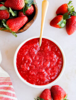 strawberry filling in a bowl with fresh strawberries all around
