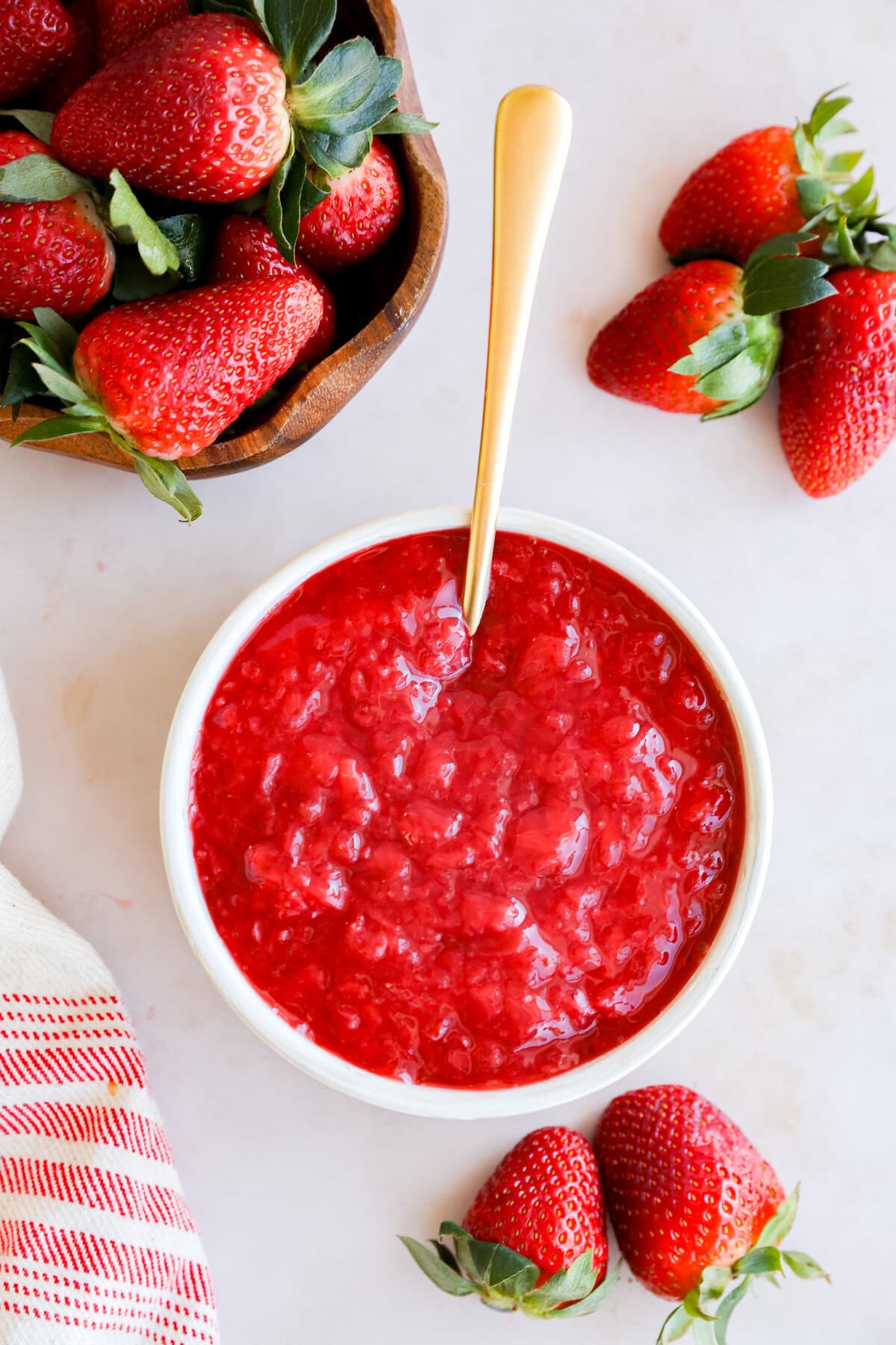 strawberry filling in a bowl with fresh strawberries all around