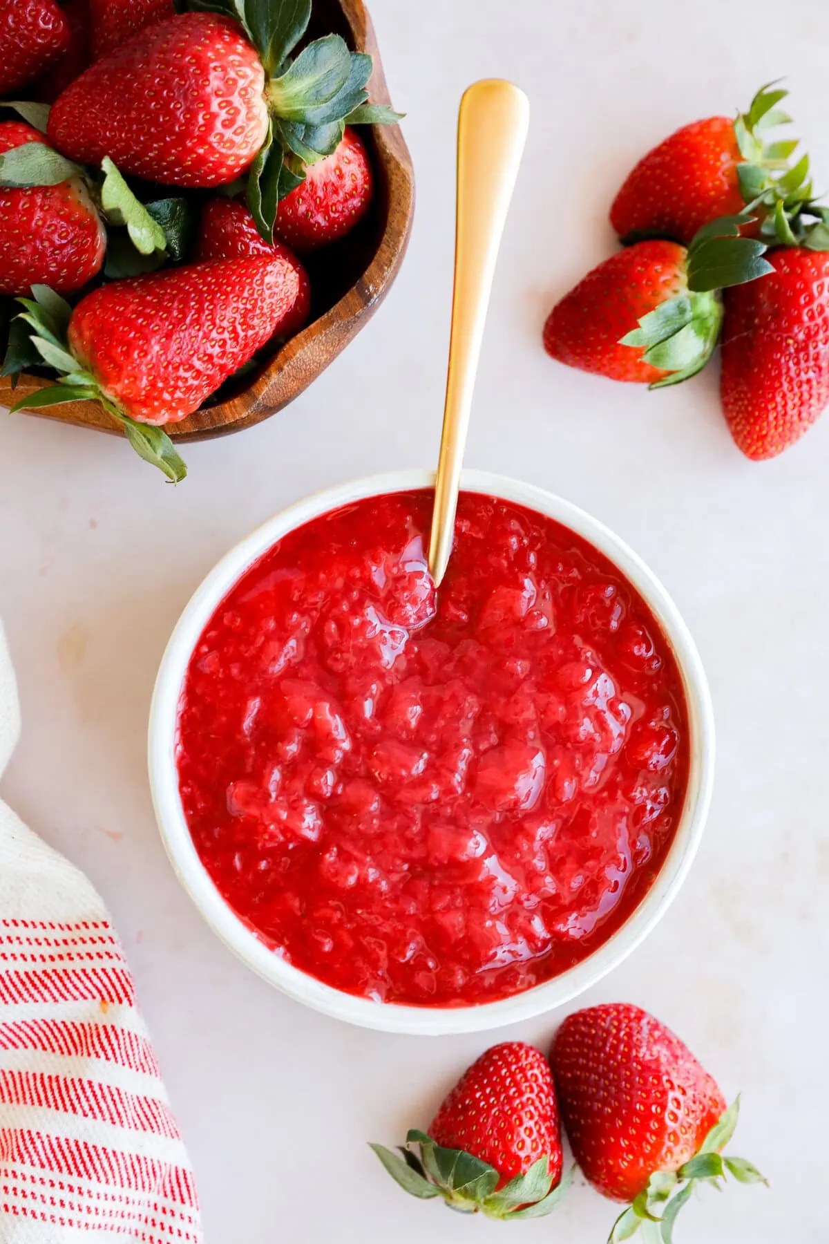 strawberry filling in a bowl with fresh strawberries all around