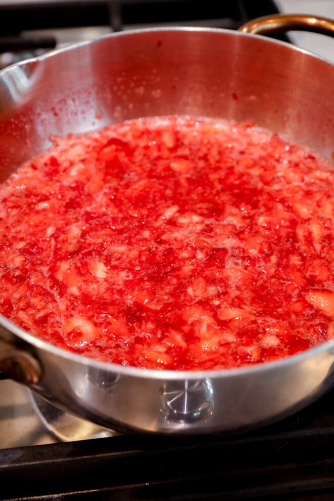 making strawberry filling on the stovetop in a saucepan