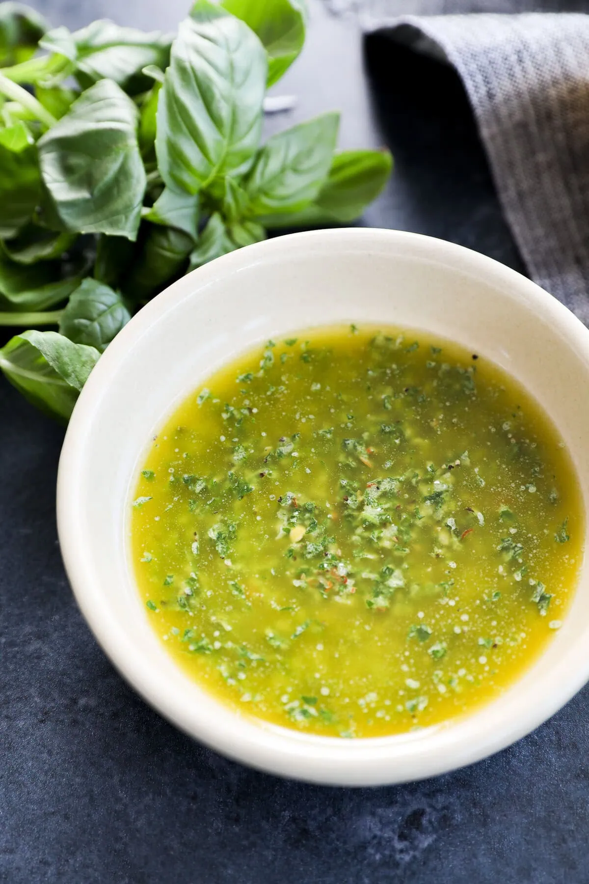 Fresh herb condiment in a bowl with fresh herbs and linen