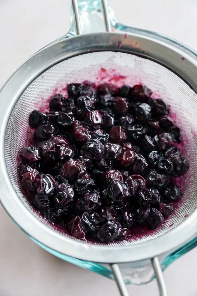 strained blueberries in sieve