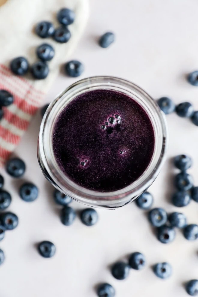 berry sweetener in mason jar with fresh berries all around with linen
