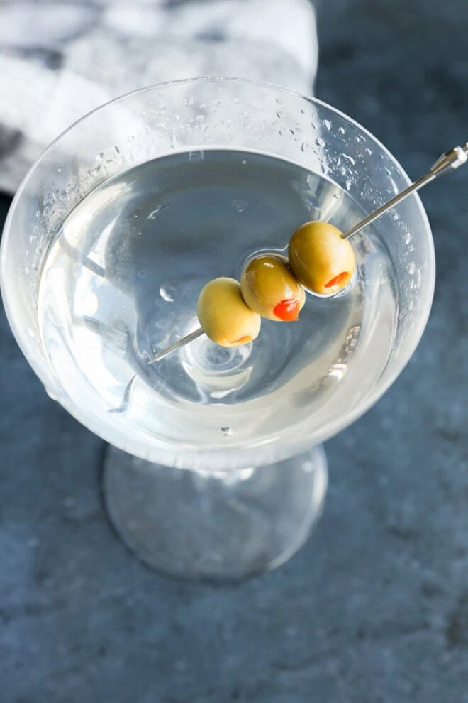 easy cocktail in coupe glass with olives garnish