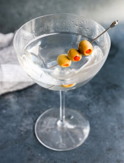 Garnished with olives gin martini in a coupe glass