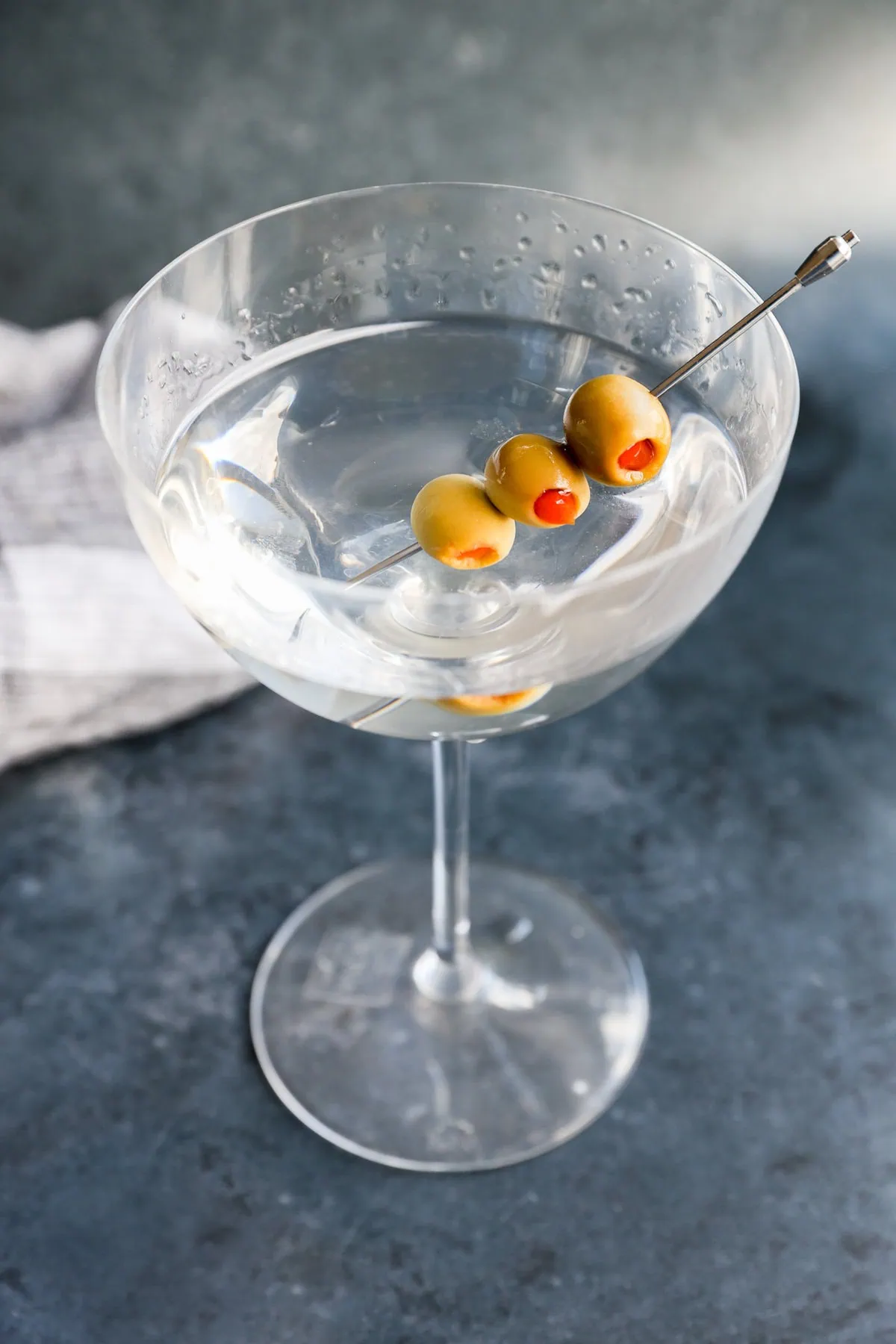 Garnished with olives gin martini in a coupe glass