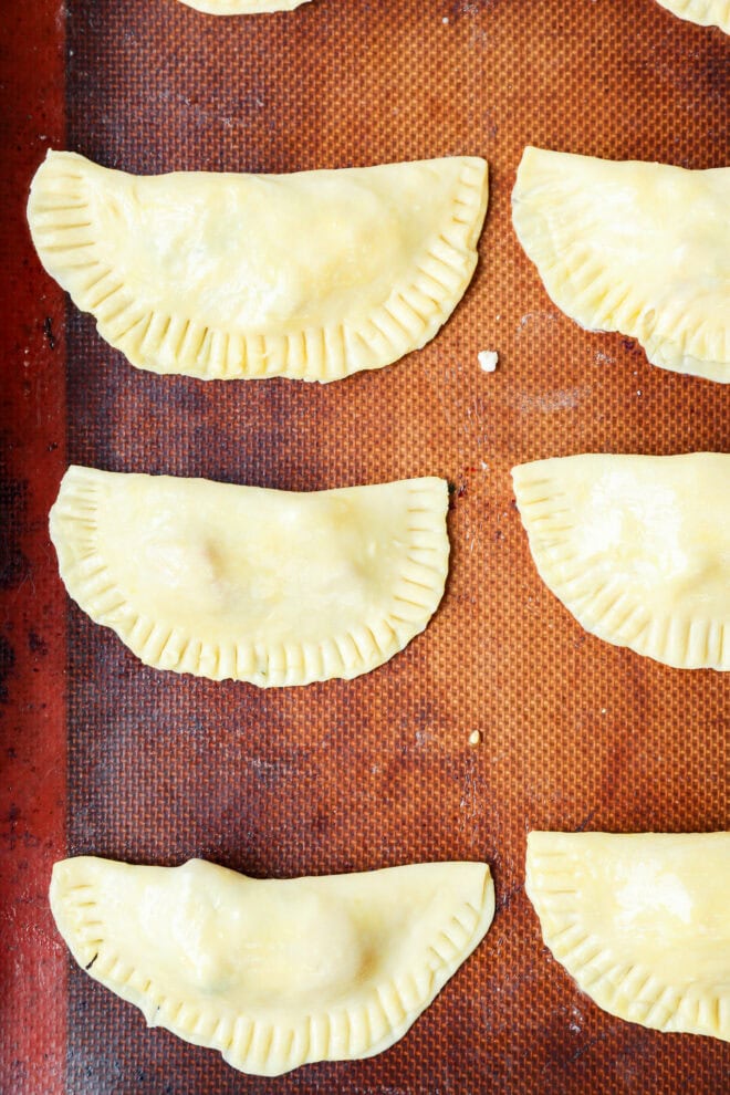 formed caprese empanadas on baking sheet before baking