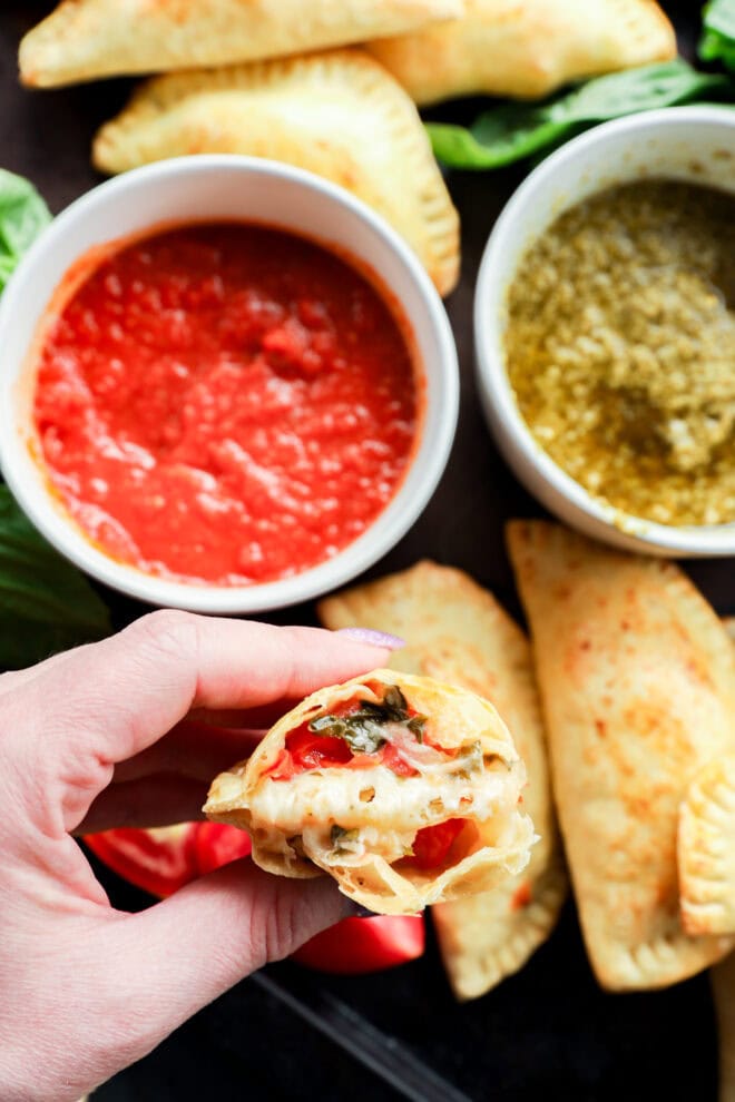 caprese empanada in half in hand