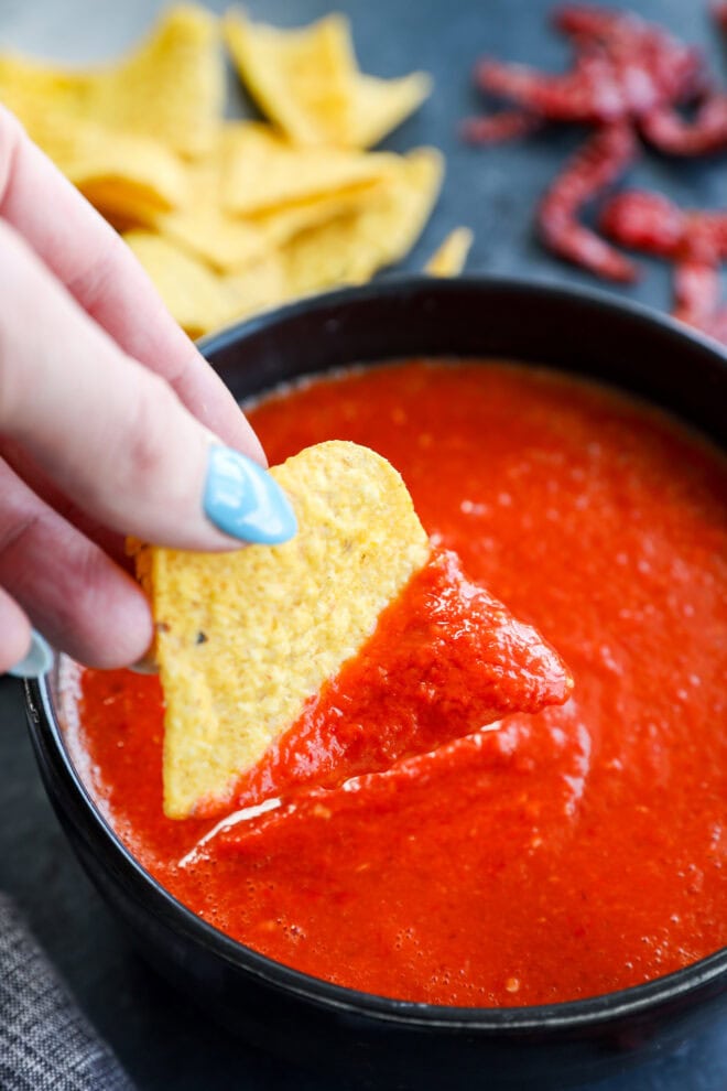 dipping a chip in chile de arbol salsa