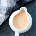 chipotle ranch salad dressing in a pouring vessel that is white and with linen