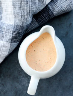 chipotle ranch salad dressing in a pouring vessel that is white and with linen