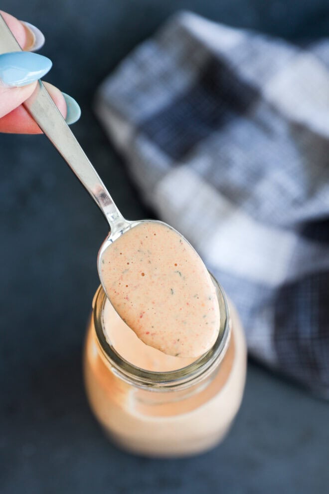 Spooning out chipotle ranch salad dressing from a glass jar