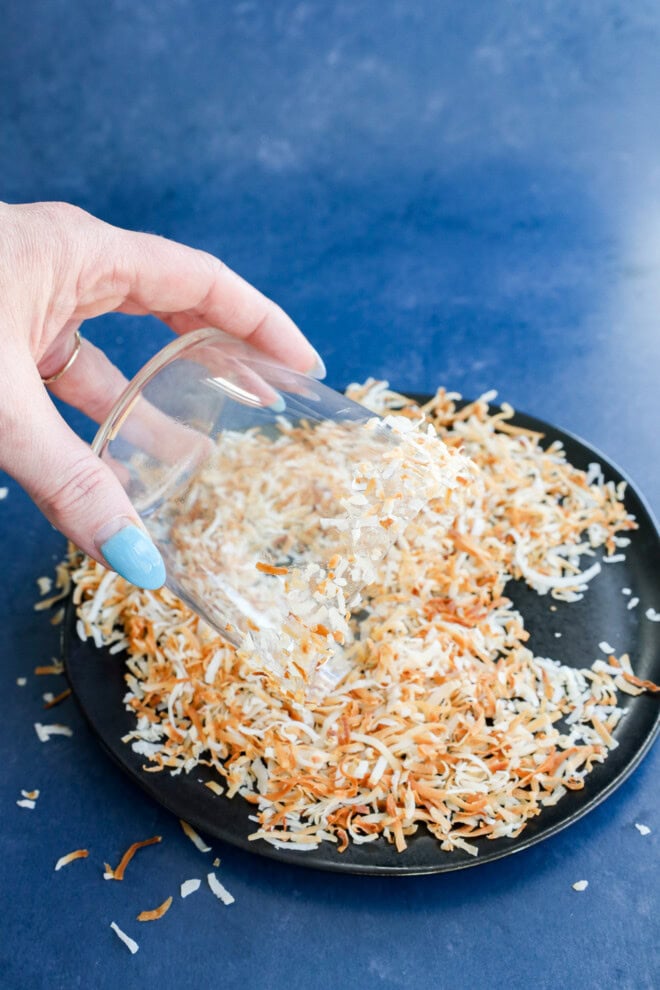Rimming a cocktail glass with toasted coconut flakes