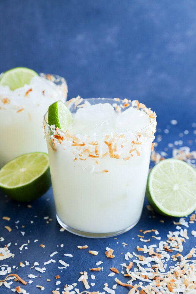 Coconut margaritas in glasses with fresh limes all around