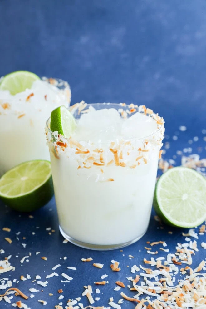 Coconut margaritas in glasses with fresh limes all around