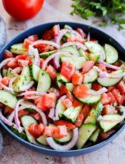 Vegetables and herbs in the background of a bowl with tons of fresh veggies for a summer side dish